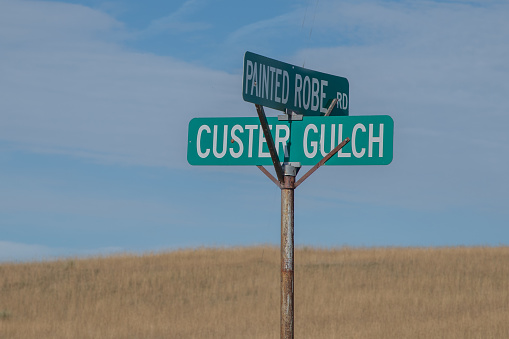 Rural ranch and farm road prairie dirt road sign far from civilization in Montana in western USA of North America. Nearest cities are Billings and Bozeman, Montana.
