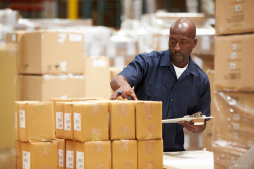 Male Worker In Warehouse Preparing Goods For Dispatch