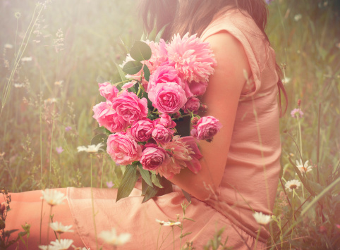 Girl holding a bouquet , focus on a bouquet, dreamy light