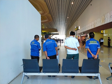 Yogyakarta, Indonesia - October 9, 2023: Team of porters are standing waiting for passengers. Airport service support team. Yogyakarta International Airport.