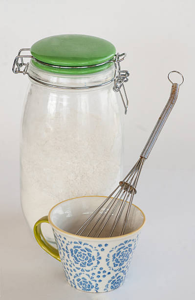 Flour jar and cup with whisk stock photo