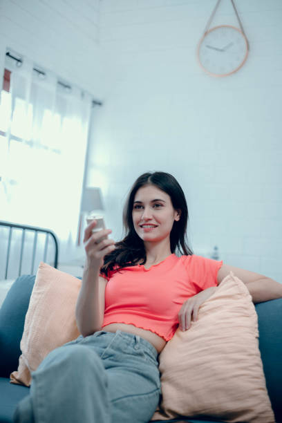 istock Woman pressing tv remote 1732602049