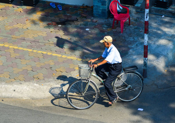 Saigon, Vietnam - Feb 1, 2019. An old man biking on street in Saigon, Vietnam. Saigon is one of the cities with the busiest transport system in Asia.