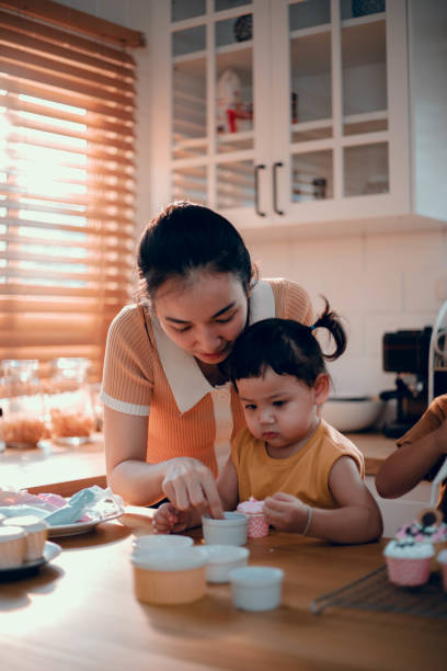pequeña niña asiática y madre horneando cocina decorar magdalenas - cake pie apple pie apple fotografías e imágenes de stock