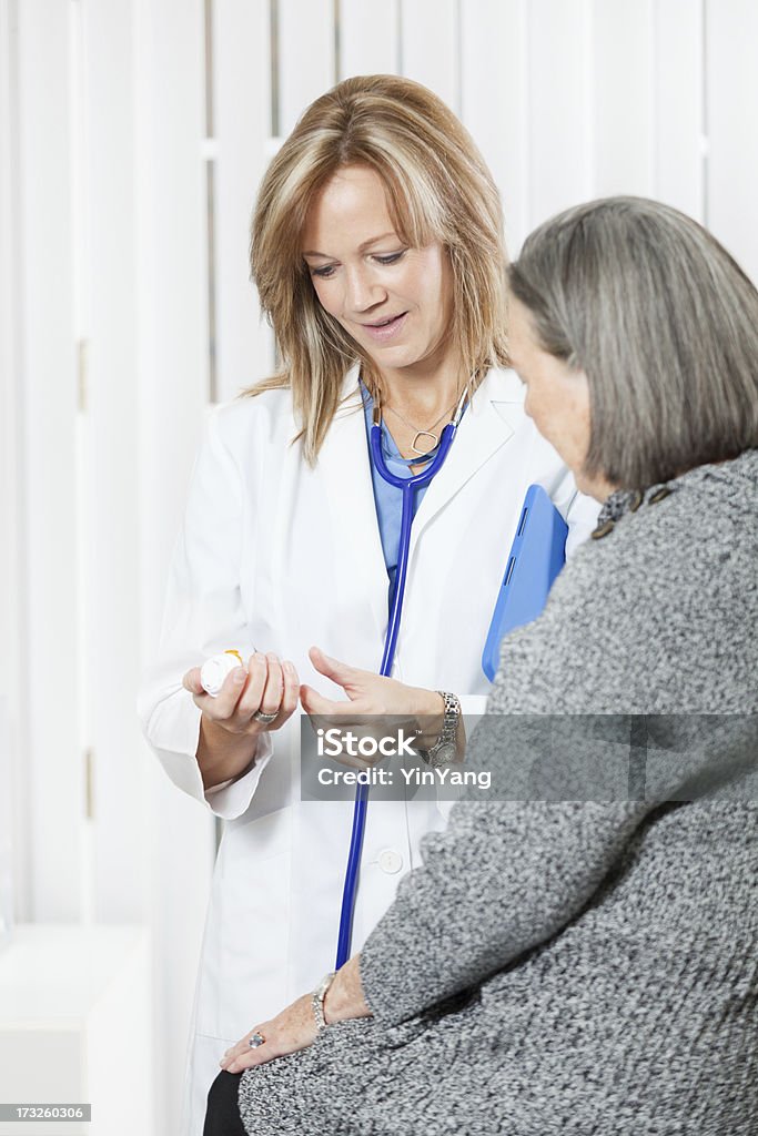 Farmaci da prescrizione medico discutere con il paziente anziano in ufficio, Vt - Foto stock royalty-free di Flacone di pillole