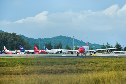 Phuket, Thailand - Apr 25, 2018. Passenger airplanes taxiing on runway of Phuket Airport (HKT).