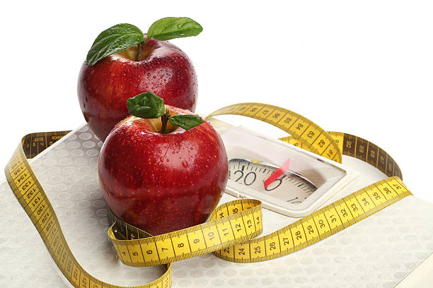 istock Red apples and a measuring tape over white 173263895