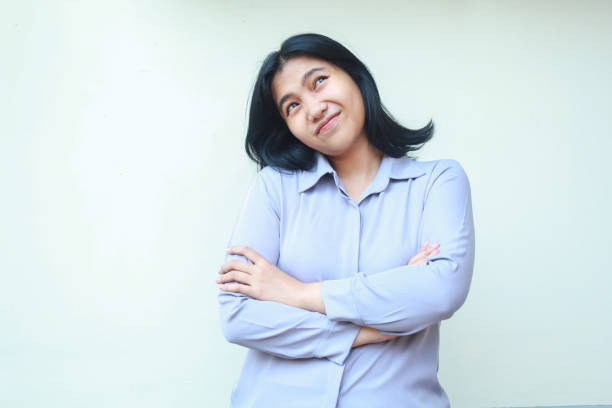 istock attractive beautiful asian young woman keep arm folded looking up thinking imagination wear formal suit isolated 1732640178