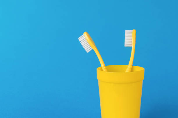 istock A pair of yellow toothbrushes on a bright blue background. 1732642067