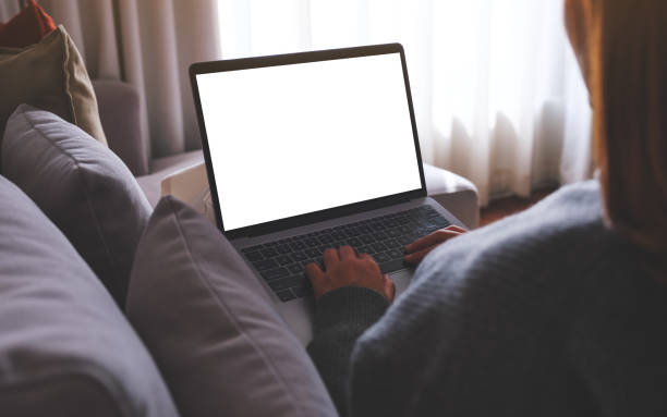 istock Mockup image of a woman working and typing on laptop computer with blank screen while sitting on sofa at home 1732654854