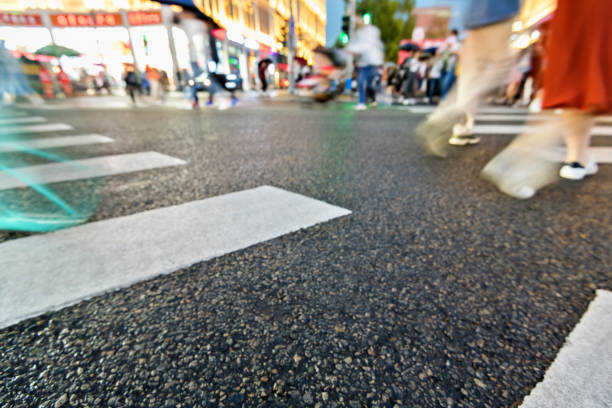 Motion blurred people walking on crosswalk.