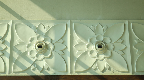 White floral decorative print on the wall. Interior wall decoration in the form of flowers