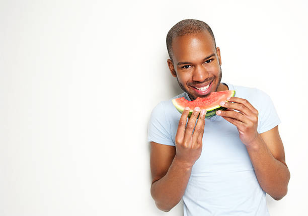 웃는 젊은 남자 옥상 및 식사 신선한 워터멜론 - watermelon fruit food portion 뉴스 사진 이미지