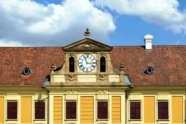 istock white round clock in decorative yellow brick exterior wall. yellow stucco exterior elevation. 1732781553