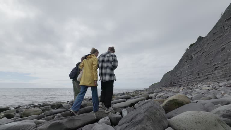 Teenagers hiking on Lyme Regis Fossil Beach in Dorset, United Kingdom