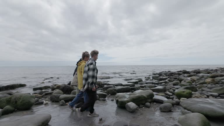 Teenagers hiking on Lyme Regis Fossil Beach in Dorset, United Kingdom