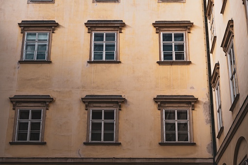 View of old and renovated facades of a street in Vienna, 1st district. The opposite houses are reflected in a modern shop window.