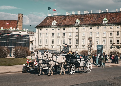 Vienna, Austria – February 08, 2023: A vintage horse-drawn carriage navigating a historic cobblestone street in Vienna, Austria