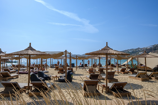 Ios, Greece - September 8, 2023 : View of luxury sun beds and sun umbrellas at the famous Mylopotas beach in Ios Greece