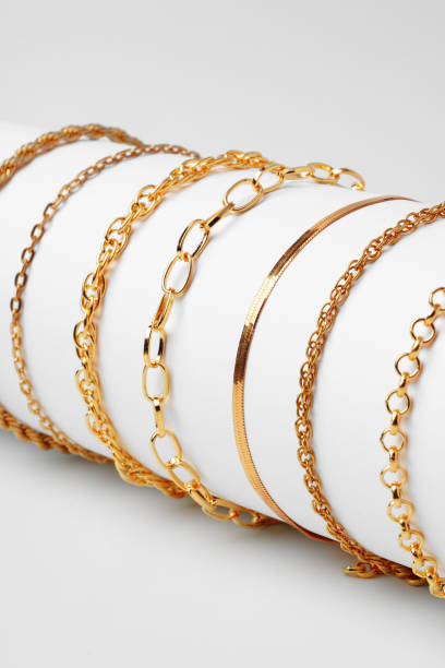 istock Set of golden bracelets on display on white background 1732889832