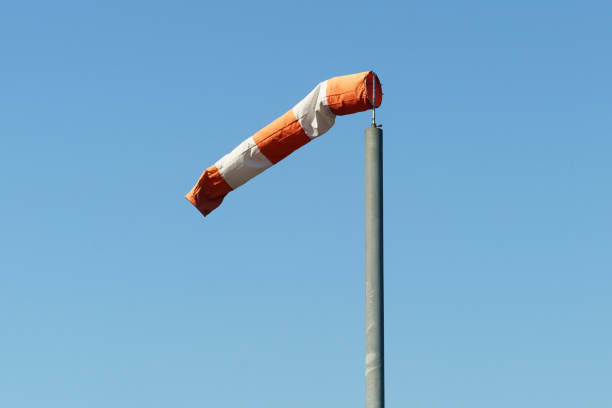 un cono de viento rojo y blanco que indica la dirección y la fuerza del viento - windsock sky natural phenomenon gale fotografías e imágenes de stock