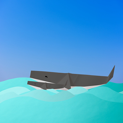 Origami Whale parent and child swimming in the ocean with copy space.\nClimate Change.