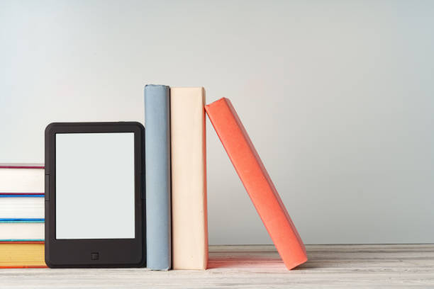 istock Digital tablet with a stack of books on gray background 1732915662