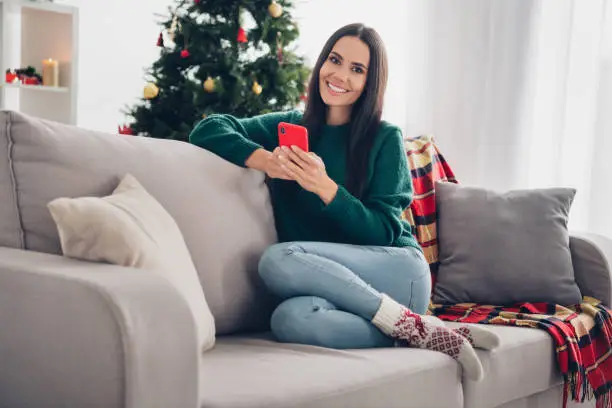 Photo of shiny sweet lady dressed knitted x-mas typing apple samsung modern device indoors house room.