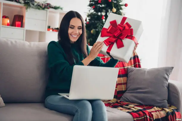 Photo of Photo of excited funny girl wear xmas green pullover shopping gifts apple samsung modern gadget box indoors home room