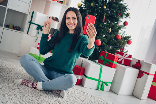 Photo of positive charming lady blogger sitting floor recording video online meeting friends demonstrate room interior room house indoors.