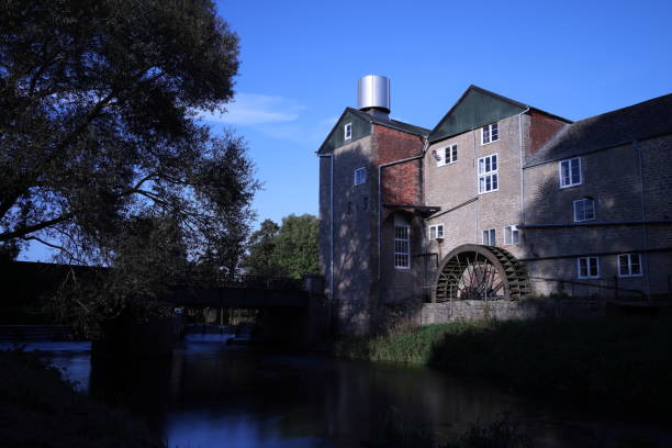 Old building with sunshine directing onto waterwheel
