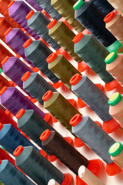 istock Row of multicolored thread spools at sewing factory 1732940897