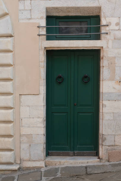 istock Old door with metal knocker surrounded by hand-crafted marble blocks 1732973027