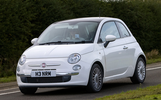 Bicester,Oxon.,UK - Oct 8th 2023: 2013 white Fiat 500  classic car driving on an English country road.