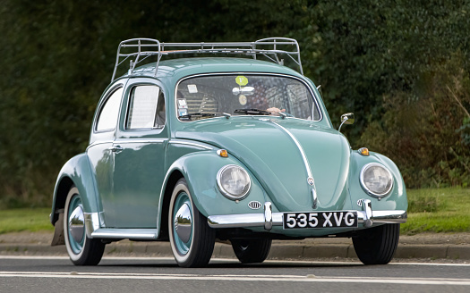 Bicester,Oxon.,UK - Oct 8th 2023: 1960 turquoise Volkswagen Beetle  classic car driving on an English country road.