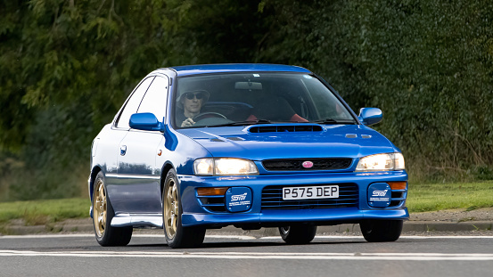 Bicester,Oxon.,UK - Oct 8th 2023: 1997 blue Subaru  classic car driving on an English country road.