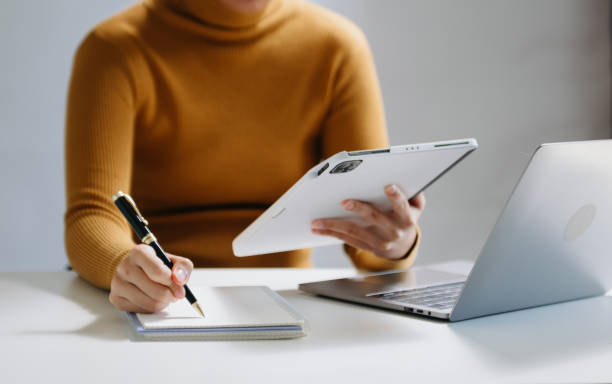 istock Close-up view of young professional businessman writing his idea concepts on notebook while working on his project 1733025685
