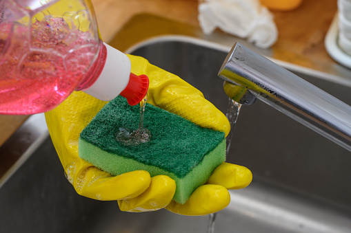 Dishwashing liquid dispensed onto a sponge closeup