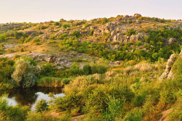 istock Hills.Warm green valley gorge with footpath and river filled with sunlight 1733046669