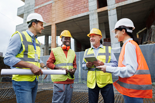 A varied group of workers performs site analysis at the construction site