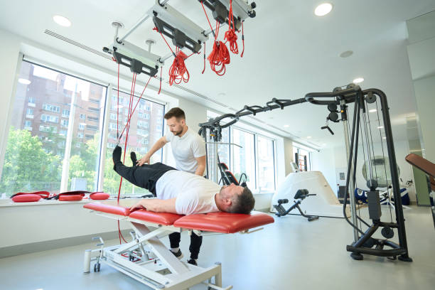 istock Man performing exercise with suspended straps assisted by gym instructor 1733049389