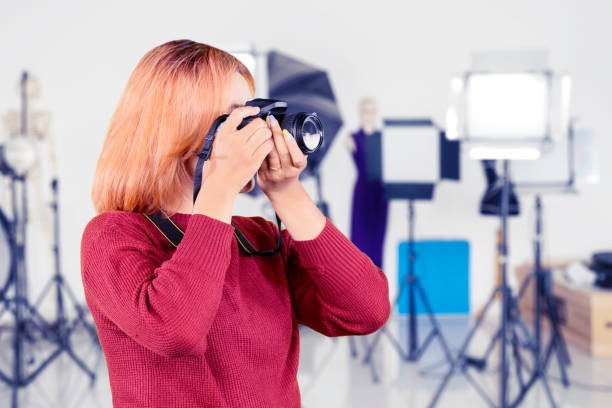 istock Young woman taking photo with studio lights 1733092442