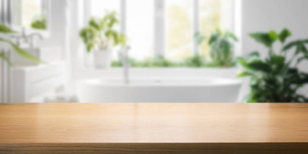 empty brown wooden tabletop for product display on blurred bright bathroom interior background stock photo