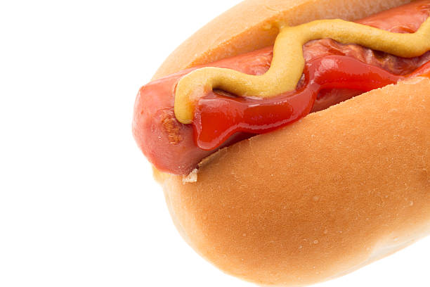 Close-up shot of a Hot dog with mustard and tomato ketcup - studio shot with a white background