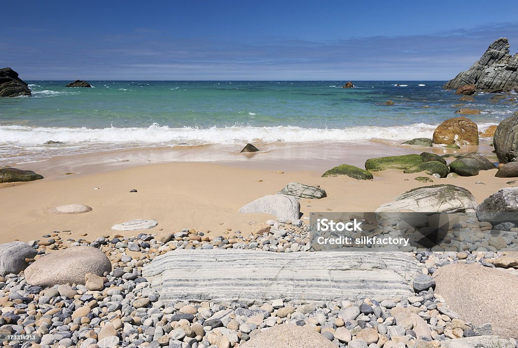 Surf, de cailloux et rochers sur une plage de sable d'été - Photo de Activité libre de droits