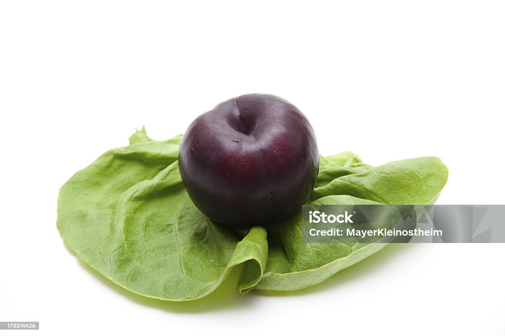 Plum on salad leaf Plum on salad leaf and on white background Food and Drink Stock Photo