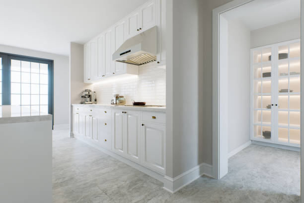 istock Kitchen with white cabinets, warm lighting and large metal hood. Kitchen interior with marble and brick tiles. 3d rendering. 1733147997