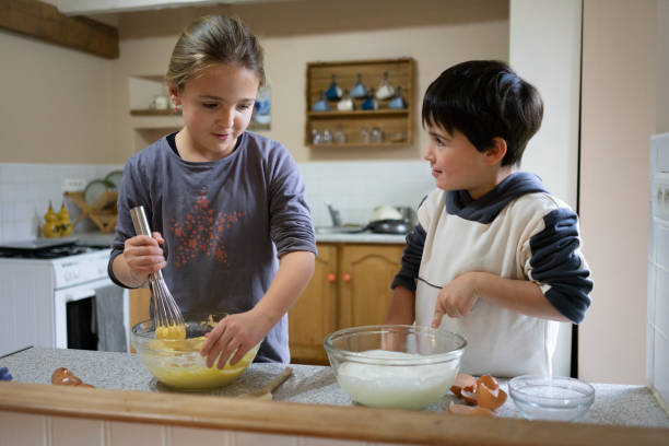 istock brother and sister baking a cake for Christmas 1733152468