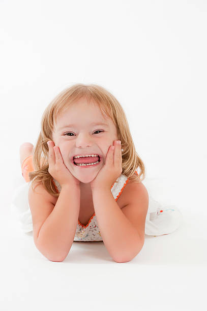 A cute little girl laying on a white background stock photo