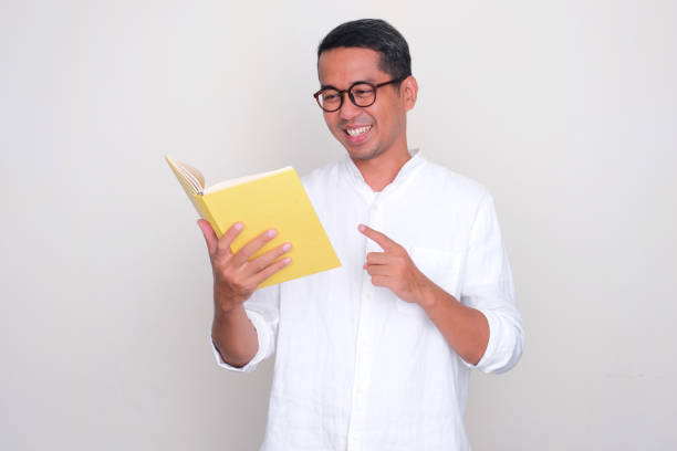 istock Adult Asian man smiling happy when reading a book 1733160795